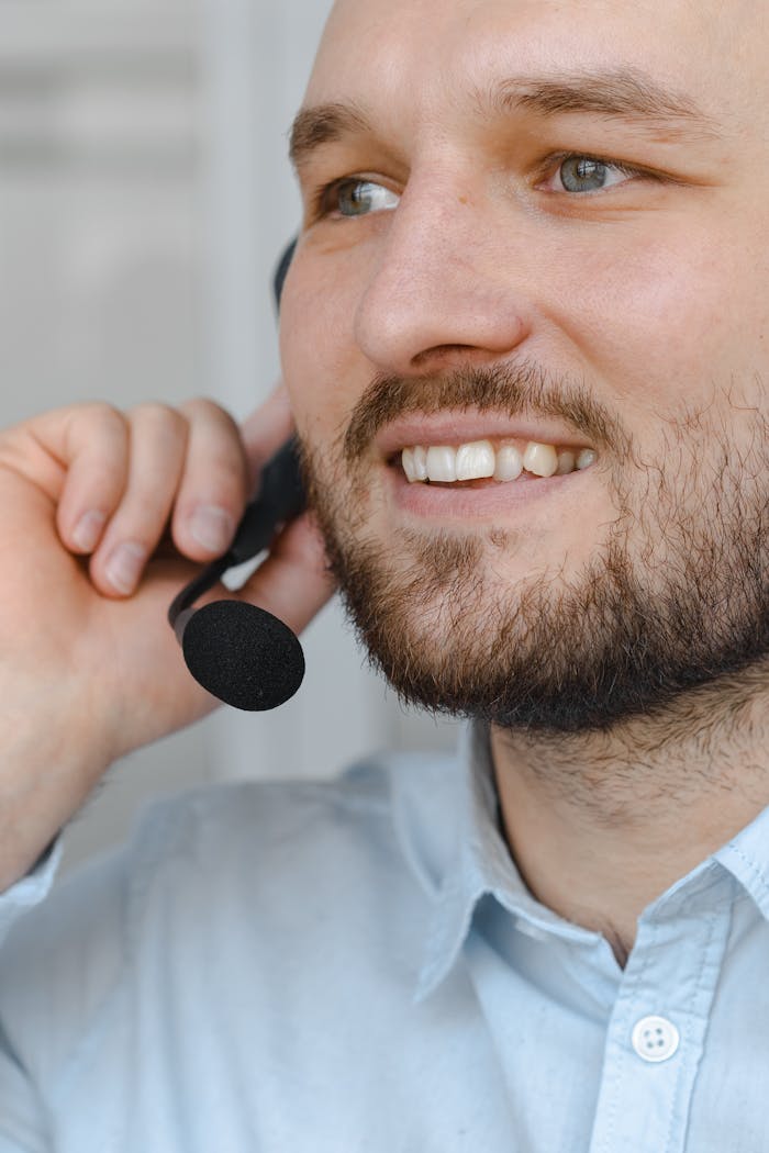 Close-up of a bearded man talking into a headset, representing friendly customer service.